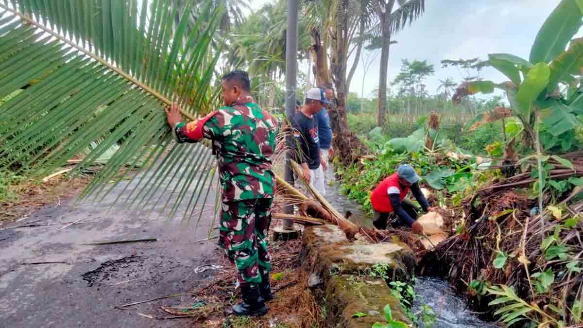 babinsa-bades-ajak-warga-gotong-royong-bersihkan-jalan-lintas-desa-di-pasirian-lumajang