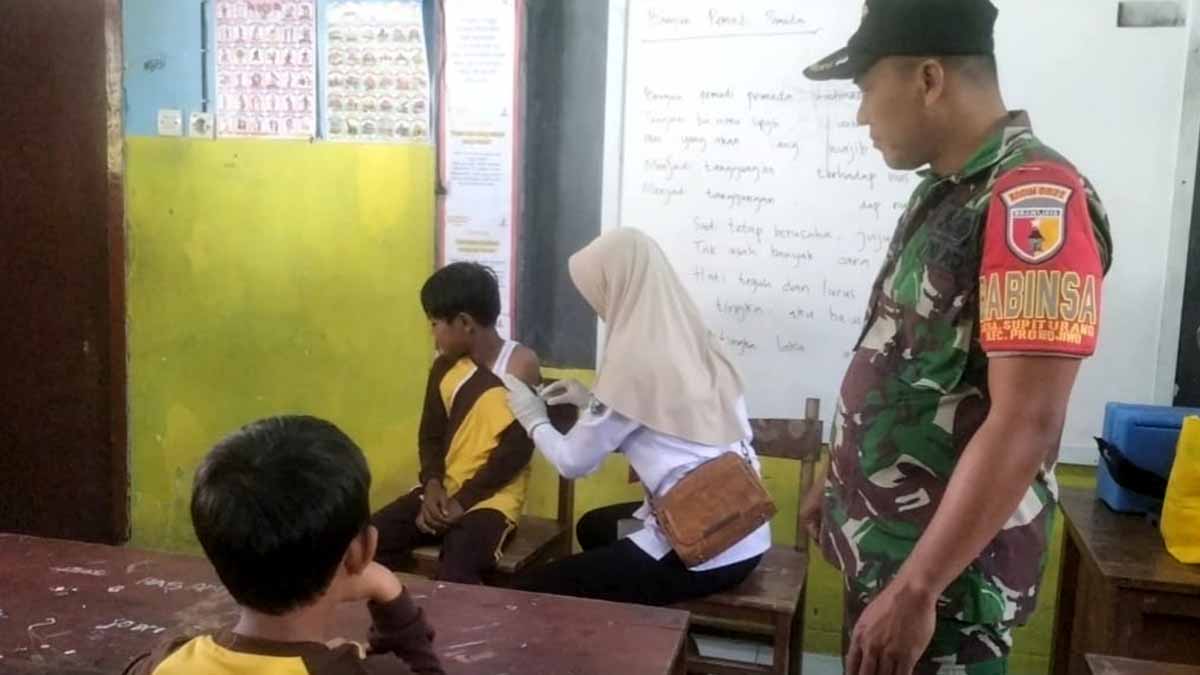 canda-babinsa-supiturang-hilangkan-ketegangan-siswa-saat-imunisasi-di-sdn-supiturang-04